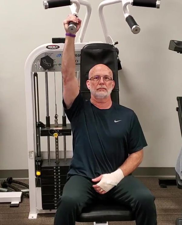 Fit over 50 Dave Durell of Strength After 50 performing a one arm shoulder press working around an injury.
