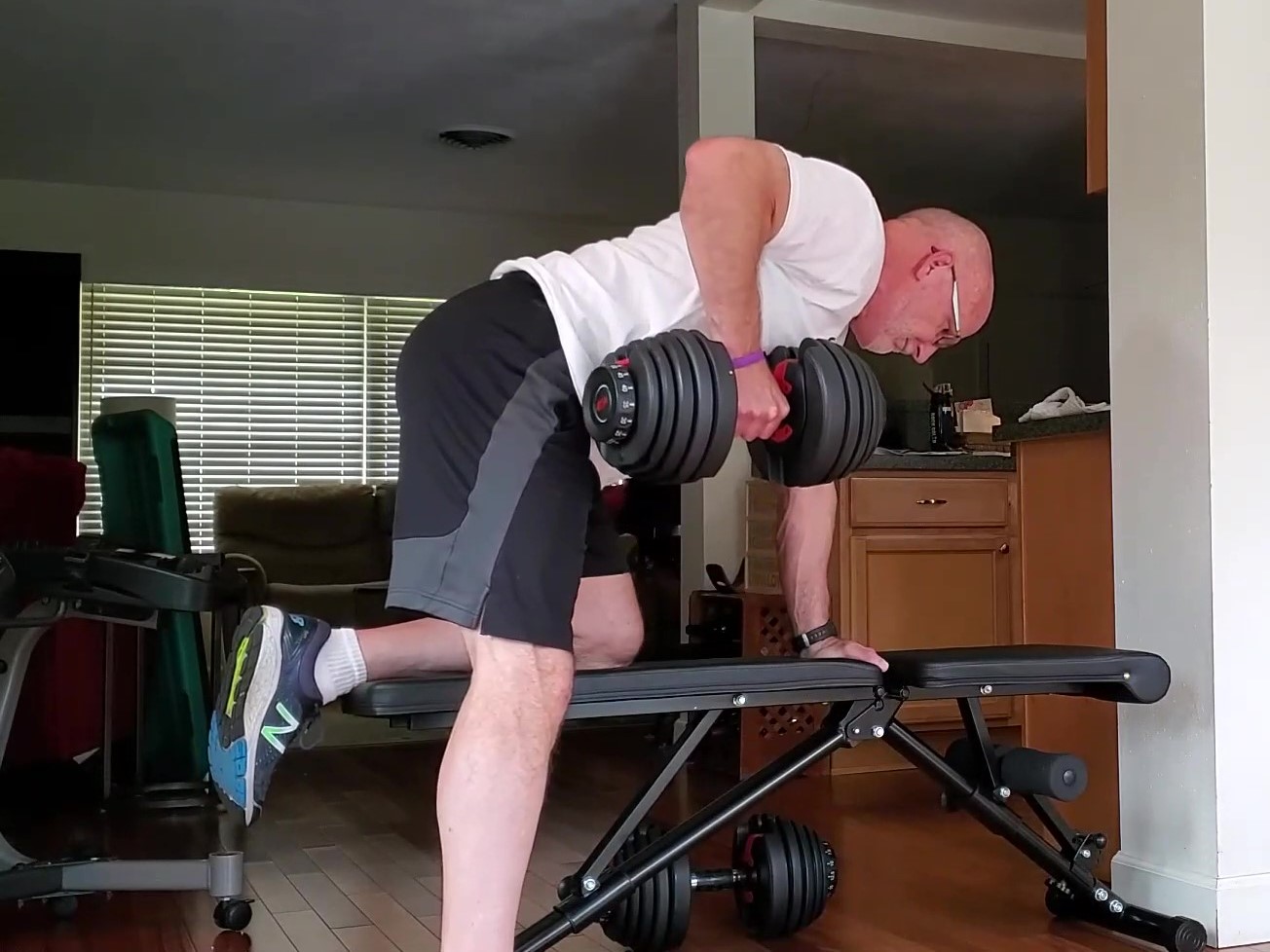 how many days a week should a 60 year old lift weights? Older man doing 1 arm dunbbell row exercise